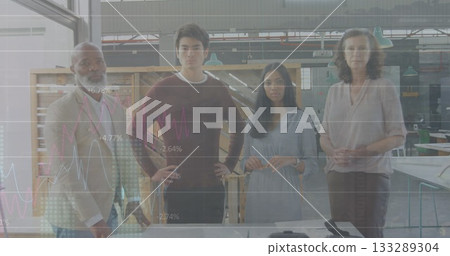 Standing diverse team of four professionals analyzing graph overlays in makerspace, with worktable 133289304