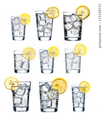 A glass filled with sparkling water, ice cubes, and a slice of lemon isolated on white transparent. A glass filled with sparkling water, ice cubes, and a slice of lemon isolated on white transparent. 133289331