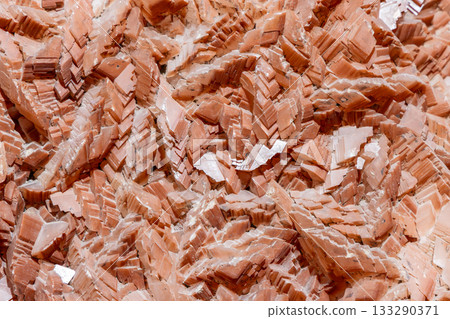Layered barite crystal formation in red and orange tones shows sharp dense tabular structure 133290371