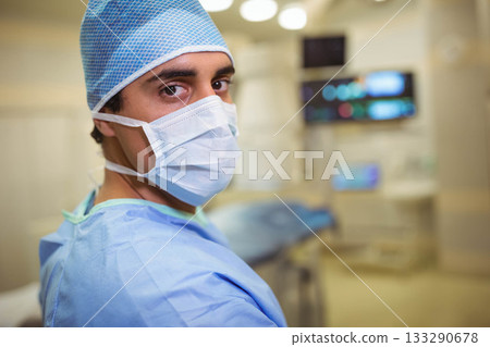 Hispanic male surgeon preparing surgery in operating room in gown, cap, mask, copy space Hispanic male surgeon preparing surgery in operating room in gown, cap, mask, copy space 133290678