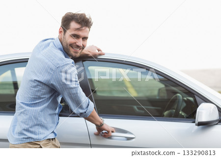 Man standing beside silver sedan on road pulling driver's door handle and checking wristwatch Man standing beside silver sedan on road pulling driver's door handle and checking wristwatch 133290813