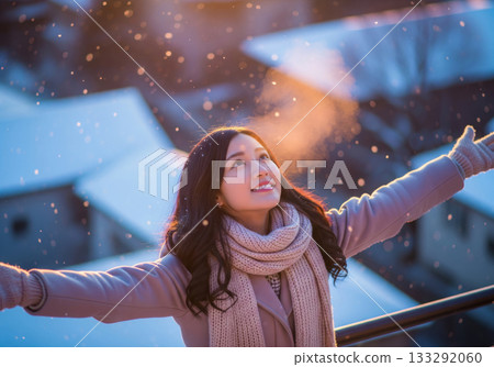 A Japanese woman smiling with her breath and warm light against the backdrop of a snowy evening cityscape A Japanese woman smiling with her breath and warm light against the backdrop of a snowy evening cityscape 133292060