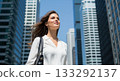 一位職業婦女在藍天和摩天大樓的環繞下，展現出獨特的風采。 133292137