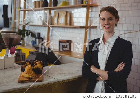 Female staff in blazer organizing pastries on marble counter at cafe using POS terminal, copy space 133292195