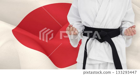 Midsection of martial artist standing against Japanese flag Midsection of martial artist standing against Japanese flag 133293447