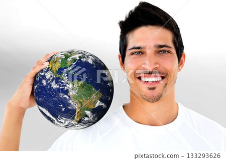 Studio shot is showing smiling man holding Earth globe next to head against plain white backdrop 133293626