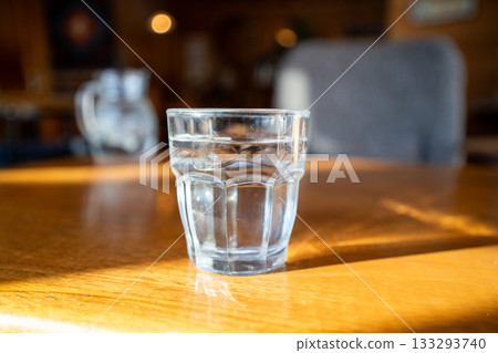 Afternoon view of a glass of clear water sparkling on a wooden table at a cafe in Abashiri, Hokkaido Afternoon view of a glass of clear water sparkling on a wooden table at a cafe in Abashiri, Hokkaido 133293740