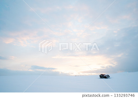A quiet winter landscape photo of a hut standing in the snowy field during the harsh winter in Kitami, Hokkaido, with the soft light of the morning glow spreading A quiet winter landscape photo of a hut standing in the snowy field during the harsh winter in Kitami, Hokkaido, with the soft light of the morning glow spreading 133293746