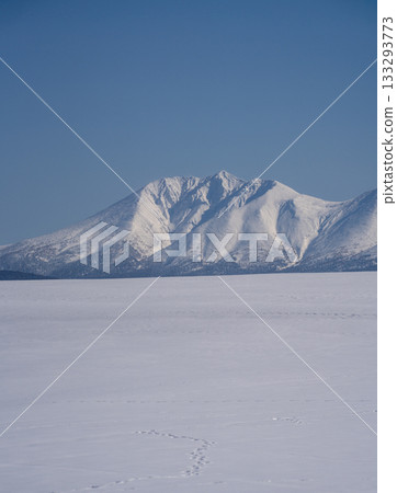 A beautiful winter landscape photograph of Mount Oputateshike towering over the snowy fields of Biei, Hokkaido, with a clear blue sky. A beautiful winter landscape photograph of Mount Oputateshike towering over the snowy fields of Biei, Hokkaido, with a clear blue sky. 133293773