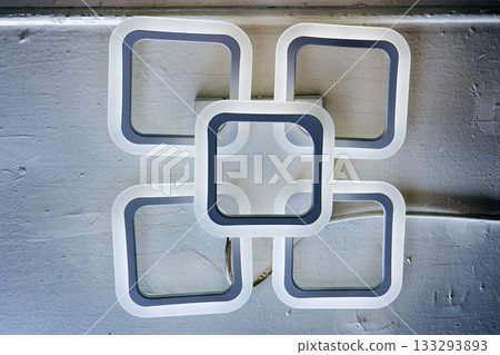 LED chandelier with interlinked square frames, white and gray color scheme, mounted on ceiling. 133293893