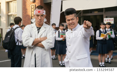 A pair of delinquents cheering on students in front of the school gates 133294587