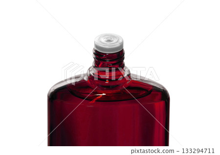 A red translucent bottle of hair growth product with the screw cap open A red translucent bottle of hair growth product with the screw cap open 133294711