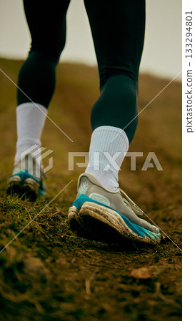 Close-up trail shoes stepping through muddy uphill path Close-up trail shoes stepping through muddy uphill path 133294801