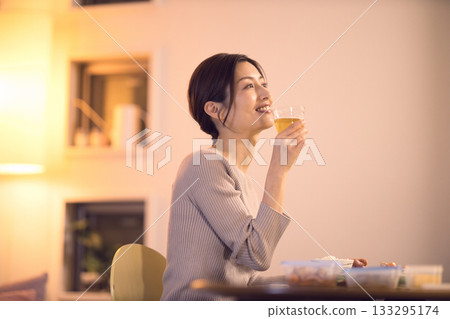 中年婦女一邊吃晚餐一邊喝啤酒 133295174