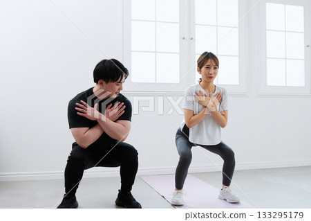 Young woman receiving training from a personal trainer Young woman receiving training from a personal trainer 133295179