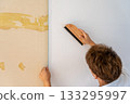 Carefully smooth out wrinkles with a brush. Wallpaper replacement. 133295997