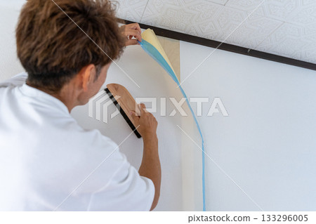一名男子小心翼翼地更換壁紙 133296005