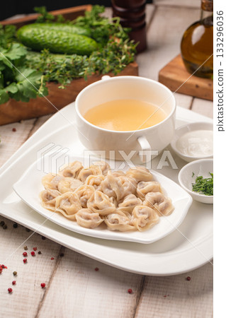 Dumplings served with hot broth and herbs 133296036