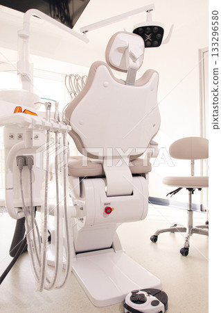 Modern dental clinic with a comfortable chair and equipment for patient care in a bright, clean environment Modern dental clinic with a comfortable chair and equipment for patient care in a bright, clean environment 133296580