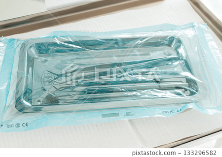 Sterile medical instruments, lying on a tray in protective packaging, dentist's instruments, preparation for a medical procedure. 133296582