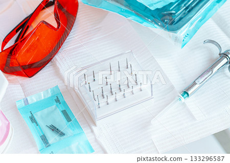 Various instruments, dental models, and hygiene items are laid out on the table in the dental office. natural light Various instruments, dental models, and hygiene items are laid out on the table in the dental office. natural light 133296587