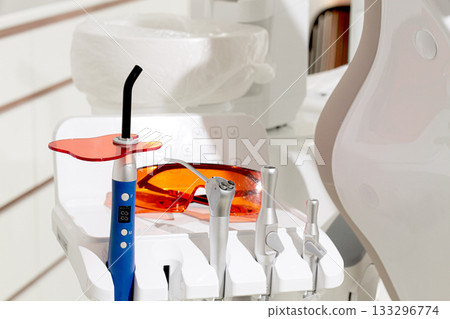 dental instruments, photopolymer lamp, safety glasses, on a modular table, 133296774