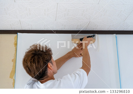 Remove excess wallpaper with a cutter 133296810