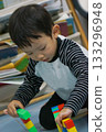 A focused child engrossed in playing with colorful blocks, a scene of creative building and developmental activity 133296948
