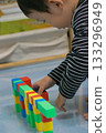 A child's hands building a structure using colorful blocks. This scene highlights creativity, learning, and play with colorful blocks. 133296949