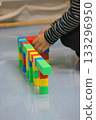 A child's hands building a structure using colorful blocks. This scene highlights creativity, learning, and play with colorful blocks. 133296950