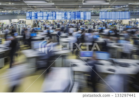 Busy trading floor with dynamic motion and blurred images of traders and screens in action 133297441