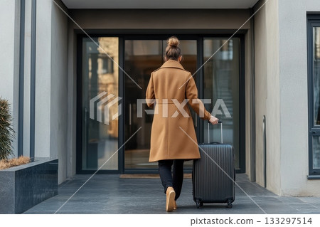 Rearview of Person Wearing Long Coat and Pulling Luggage Outside Rearview of Person Wearing Long Coat and Pulling Luggage Outside 133297514