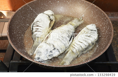 cooking freshwater fish crucian carp in a frying pan 133298419