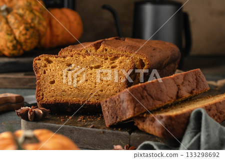 Pumpkin bread freshly baked sliced on a serving wooden board. Traditional Thanksgiving dessert Pumpkin bread freshly baked sliced on a serving wooden board. Traditional Thanksgiving dessert 133298692