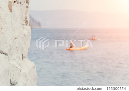 Kayaking, Coast, Sunset - Kayaking in the ocean near a rocky coast at sunset. Kayaking, Coast, Sunset - Kayaking in the ocean near a rocky coast at sunset. 133300554