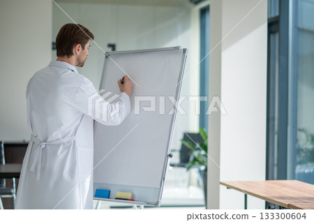 Physician standing by whiteboard ready for lecture indoors Physician standing by whiteboard ready for lecture indoors 133300604