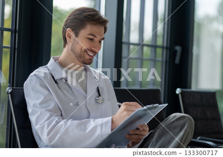 Doctor with stethoscope writing in folder 133300717