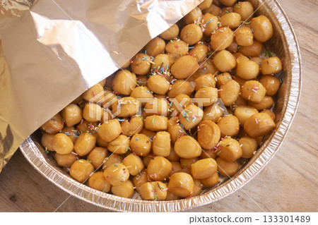 traditional italian pignolata honey balls with sprinkles in foil pan 133301489