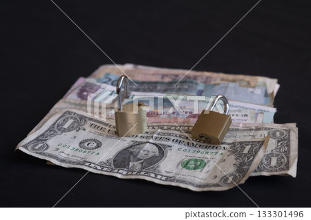 stack of international currency bills secured with padlocks on black stack of international currency bills secured with padlocks on black 133301496