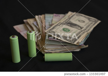 green batteries and cash money on black background for a financial concept green batteries and cash money on black background for a financial concept 133301497