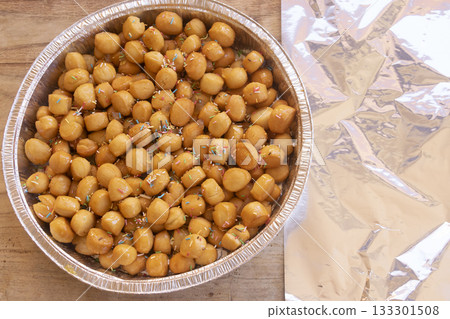 traditional italian pignolata honey balls with sprinkles in foil pan 133301508