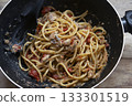 spaghetti with anchovies and cherry tomatoes in black pan on table 133301519