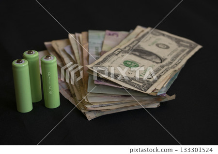 expensive green batteries and cash money for concept of high energy costs financial burden 133301524
