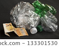 euro banknotes on crushed plastic bottles waste symbolizing pollution 133301530