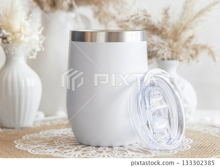 White stainless steel 12oz tumbler on boho placemat near pampas grass Closeup, mockup White stainless steel 12oz tumbler on boho placemat near pampas grass Closeup, mockup 133302385