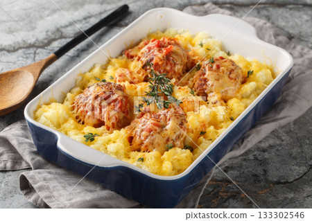 Hot mashed potatoes with Italian meatballs baked with cheese and herbs close-up in a baking dish. Horizontal Hot mashed potatoes with Italian meatballs baked with cheese and herbs close-up in a baking dish. Horizontal 133302546