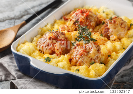 Homemade baked meatballs with mashed potatoes, cheddar, tomato sauce, and herbs in a baking dish. Horizontal Homemade baked meatballs with mashed potatoes, cheddar, tomato sauce, and herbs in a baking dish. Horizontal 133302547