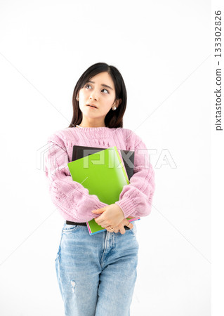 年輕女子手持筆記本和文件站在那裡 年輕女子手持筆記本和文件站在那裡 133302826