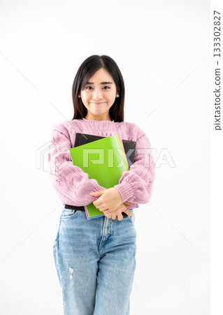 年輕女子手持筆記本和文件站在那裡 年輕女子手持筆記本和文件站在那裡 133302827
