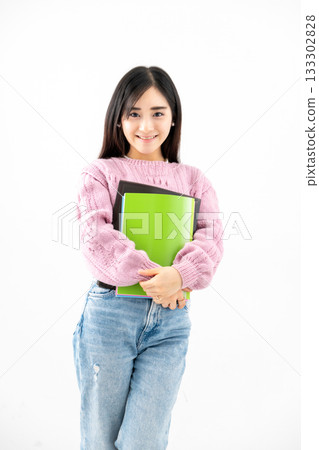 年輕女子手持筆記本和文件站在那裡 年輕女子手持筆記本和文件站在那裡 133302828